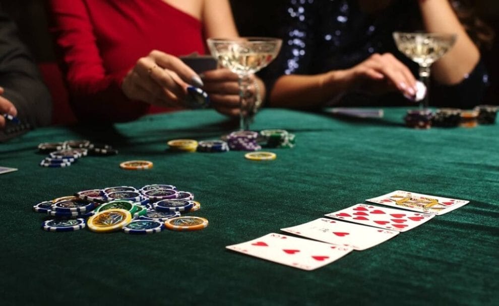 Poker chips and dice lie on the table against the background of players at a casino.