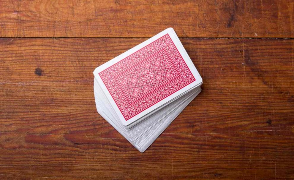 A deck of cards on a wooden table.
