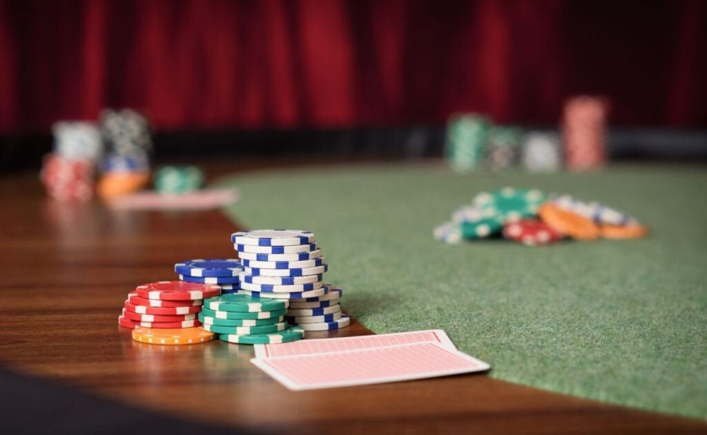 A poker table with casino chips and playing cards.