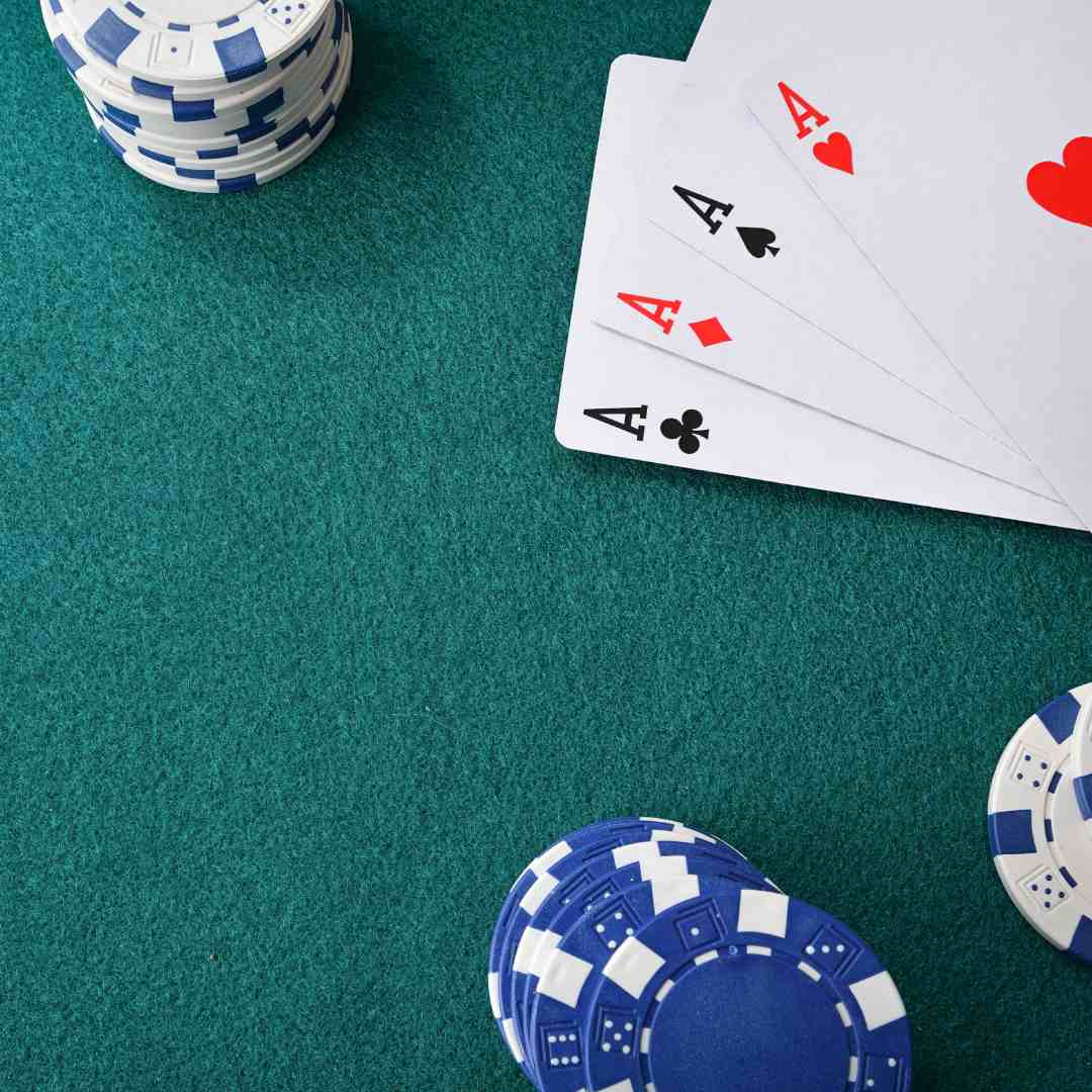 Ace playing cards and casino chips on a poker table.