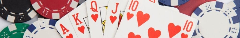 A closeup image of an Ace of Hearts, a King of Hearts, a Queen of Hearts, a Jack of Hearts, and a ten of Hearts, strategically placed on top of poker chips.
