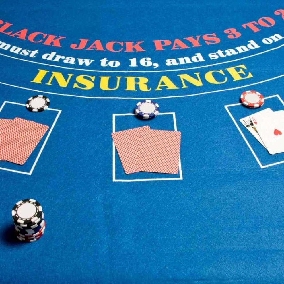 A closeup of a blackjack table with a focus on the words “insurance” printed on it.