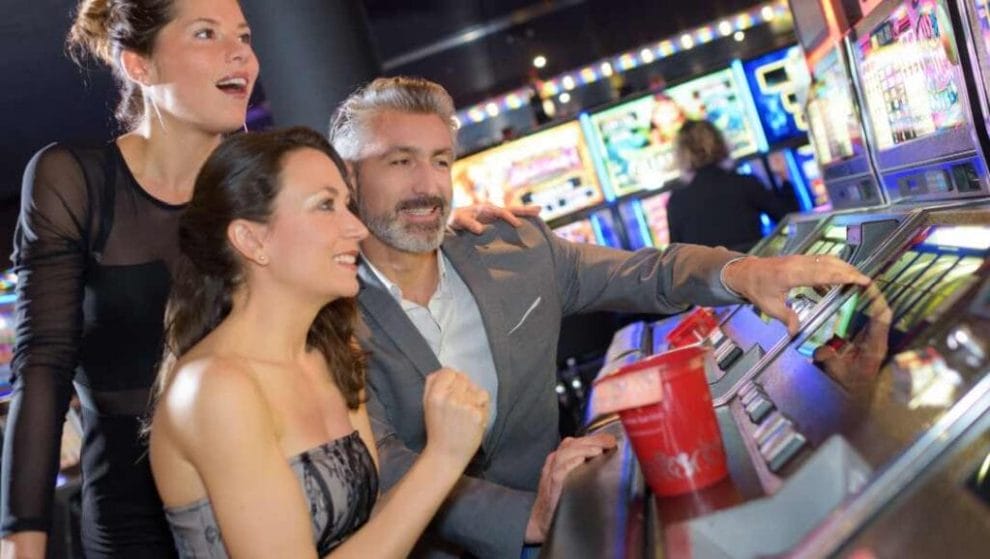 A group of friends playing slots in a casino together.