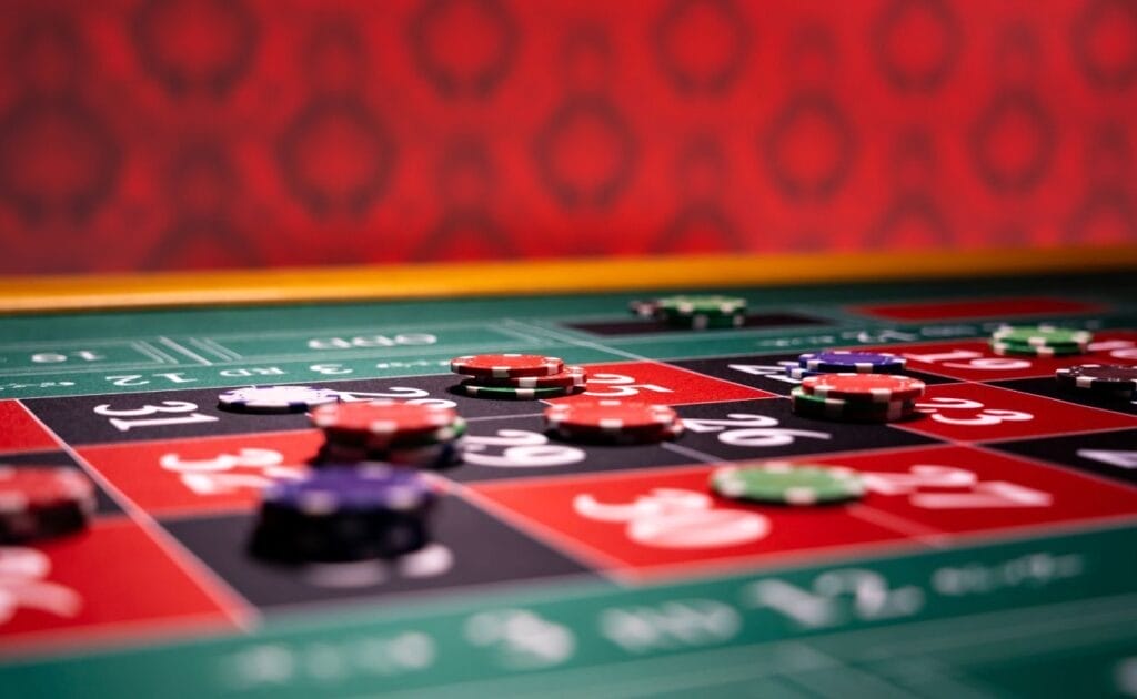 A roulette table with different colored chips placed on various numbers.