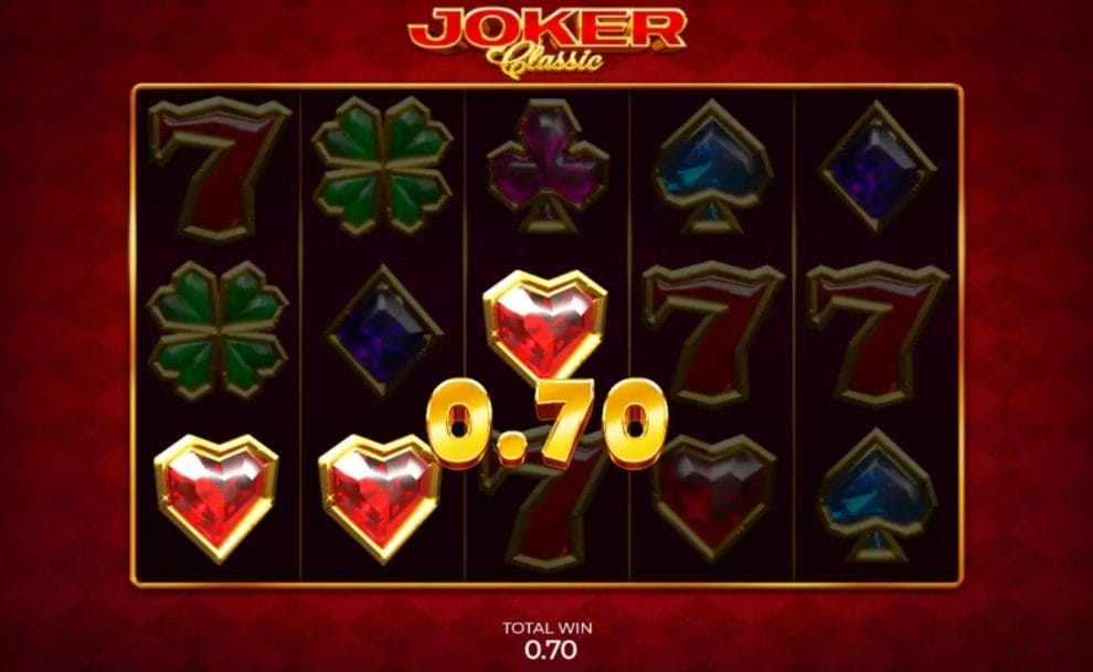 Gameplay in Joker Classic Slot by Armadillo Studios showing a total win symbol of 0.70, gem-like symbols and 7s symbols are in the background