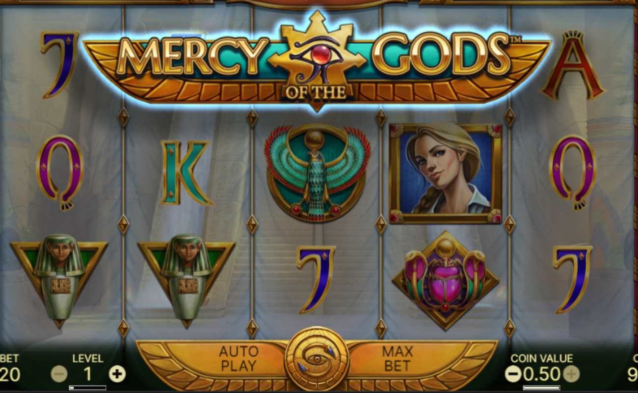 Mercy of the Gods reels feature mummy symbols and playing card symbols in gold and gemstone colors, with an Egyptian tomb in the background.
