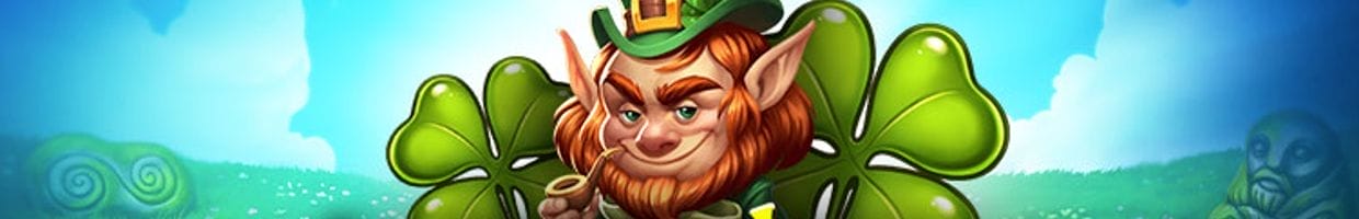 Leprechaun Goes Wild online slot loading screen, featuring a smug-looking cartoon leprechaun with a green and gold hat on his head and gold pipe in his mouth, surrounded by four leaf clovers in a grassy field against blue cloudy skies.