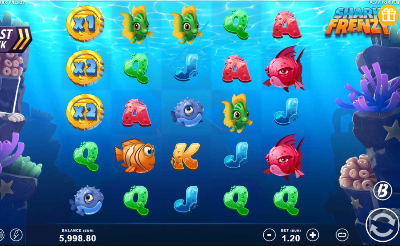 Shark Frenzy online slot reels with orange, blue, green and red fish alongside playing card symbols. Coral reef is seen on both sides of the screen.
