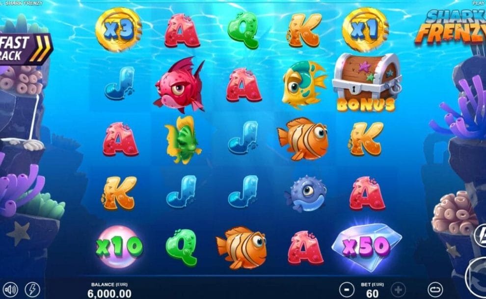 A screenshot of the Shark Frenzy slot. The game is set against the picturesque ocean floor with coral on both the left and right sides of the screen. The reels contain a variety of cartoon symbols, including fish, pearls, gems, and treasure chests.