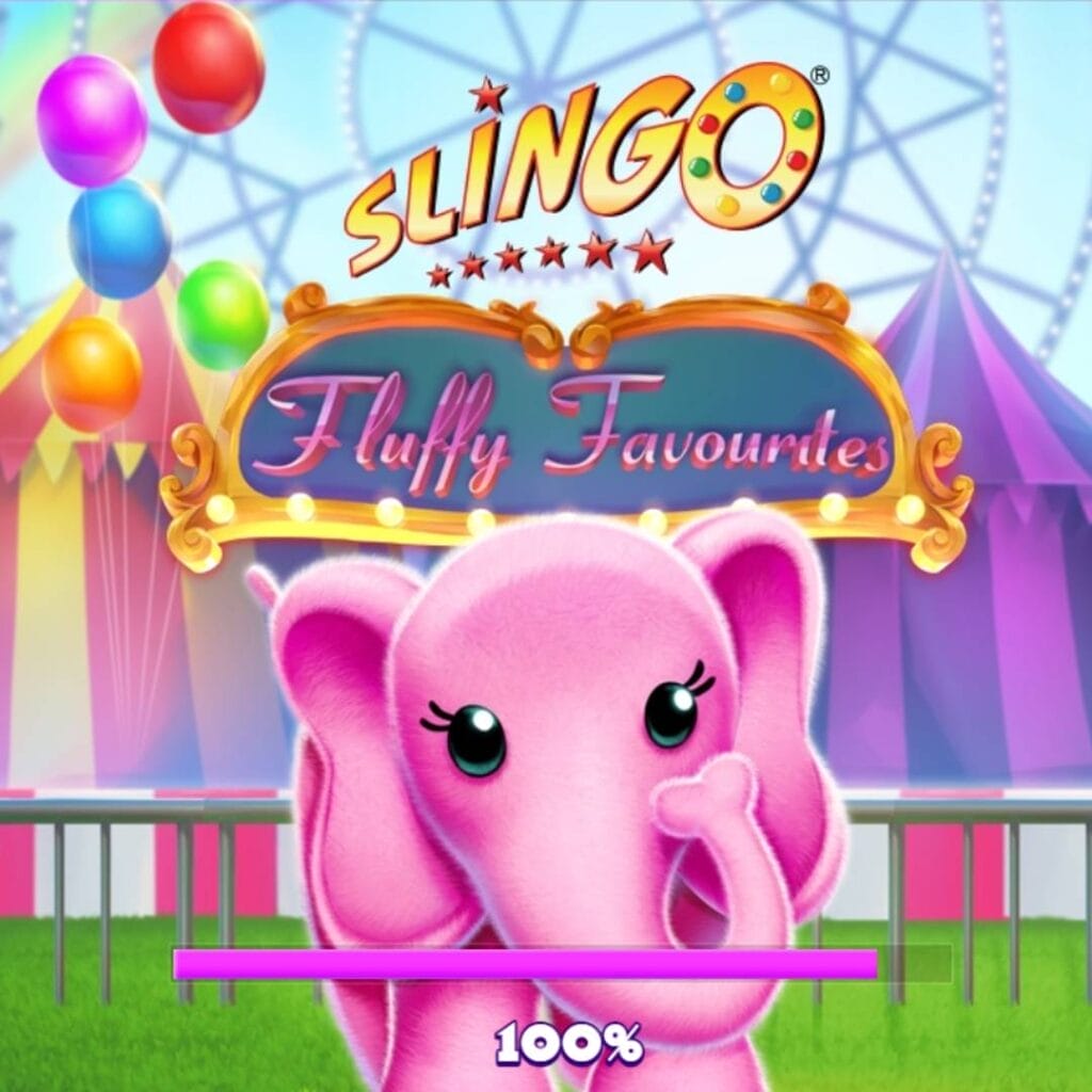A screenshot of the Slingo Fluffy Favorites title screen. The game’s title is displayed in a cute font on an intricately detailed frame with lights. This frame sits in front of the tents at a carnival, and balloons surround the carnival setting.