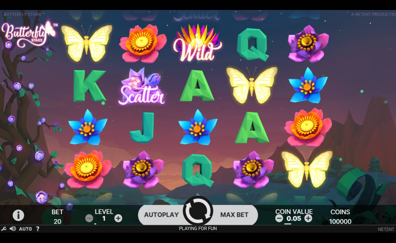 A screenshot of the Butterfly Staxx reels. The background is a forest and mountain range that pierce the horizon as the sun sets. The slot symbols include various flower symbols, butterflies, and a number of standard symbols like the A, K, Q, and J.