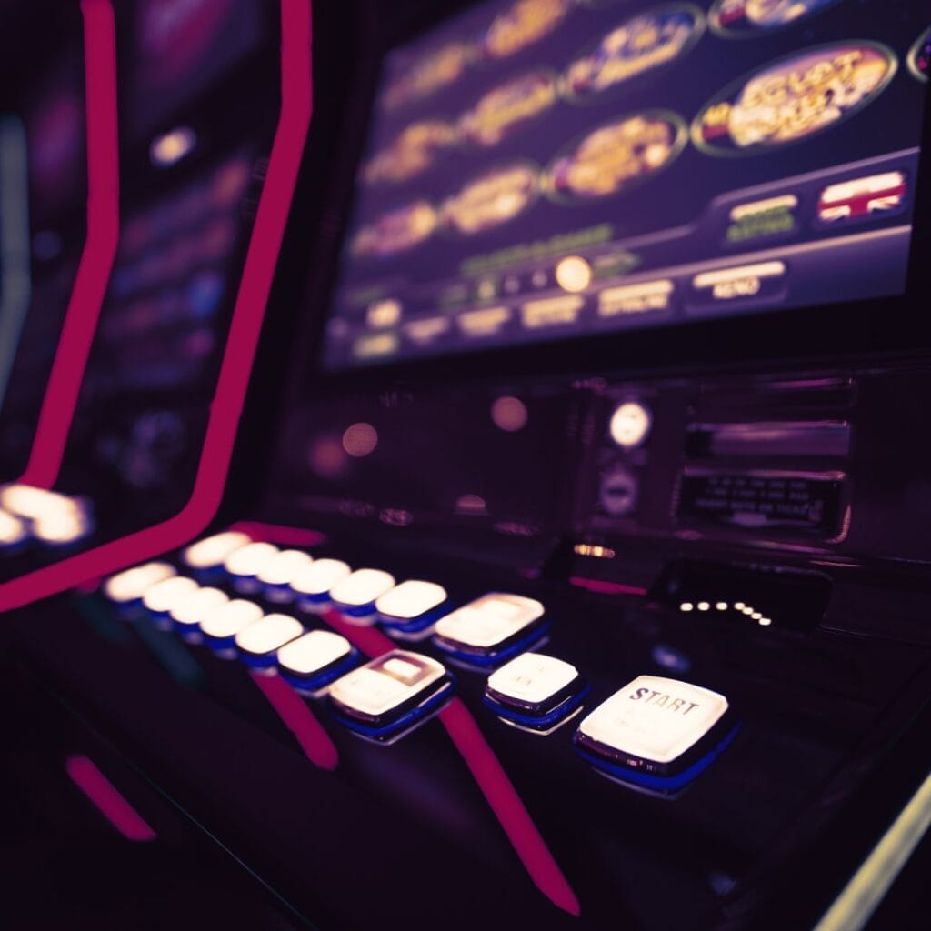 A slot machine at a casino with white buttons and a slot machine screen.