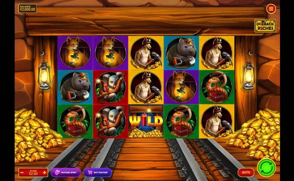 A screenshot of the Outback Riches reels. This setting for this slot is a mine shaft with mining cart tracks in the center of the screen and piles of gold on either side. The reels are set between the supports of the mineshaft and feature a dog with a lantern, a kangaroo with a pickax, a wombat with a shovel, a koala with a stick of dynamite, and a snake with a TNT detonator.