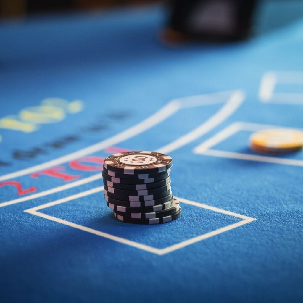 Black and yellow casino chips on a blue felt table.