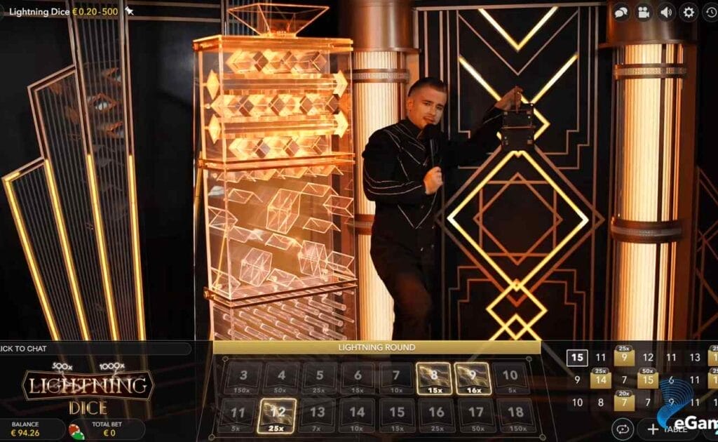 Lightning Dice online casino game. The live dealer is wearing a black suit. The background is gold and black. 