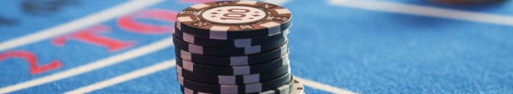 Black and yellow casino chips on a blue felt table.