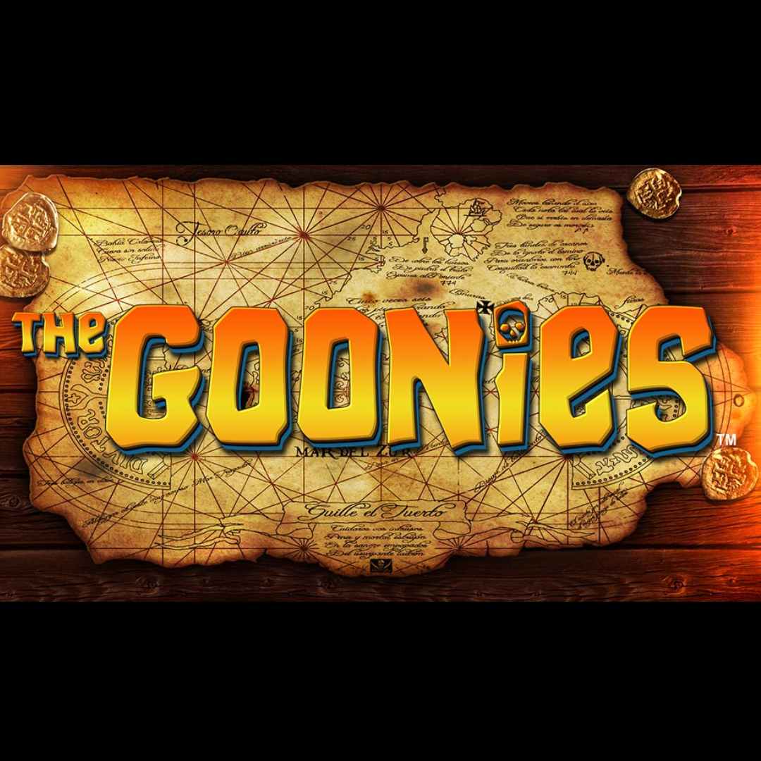 The Goonies online slot game logo in yellow, orange and blue. The font is against a map. The map is on a wooden table with gold coins.