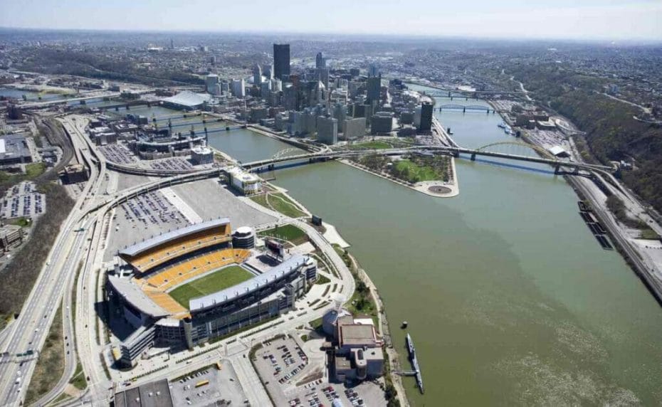 Aerial view of Pittsburgh, Pennsylvania, with skyscrapers, stadium, and rivers.