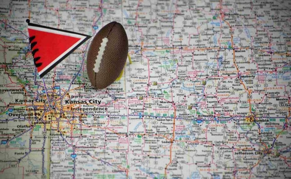 Macro shot of a flag and football placed on Kansas City, Missouri on a map.