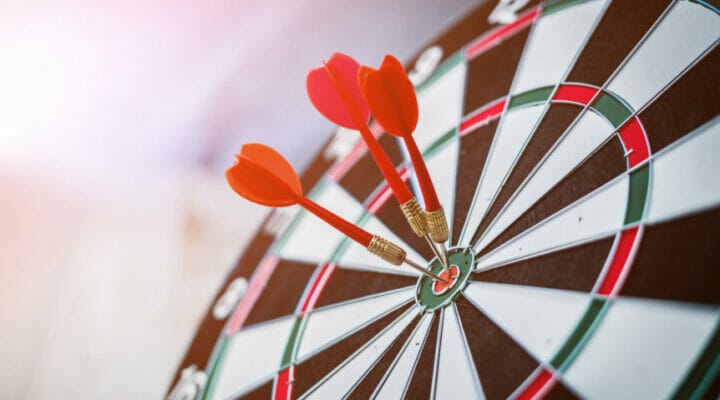 Close-up of a dartboard with bullseye darts against a blurred background.