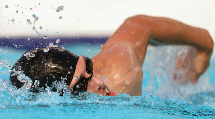 A male athlete swims freestyle.