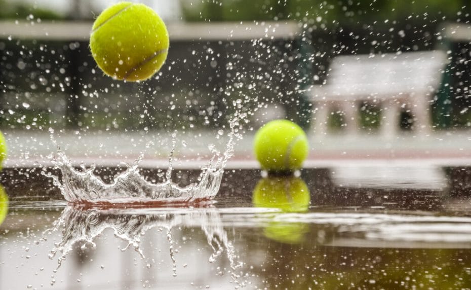 A tennis ball bounces in a puddle of water.