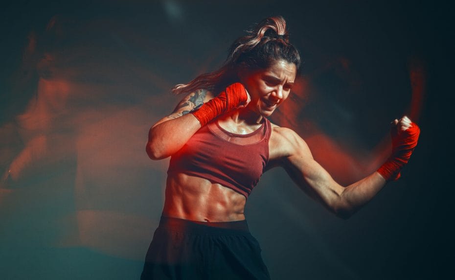 A fit woman practices MMA moves.
