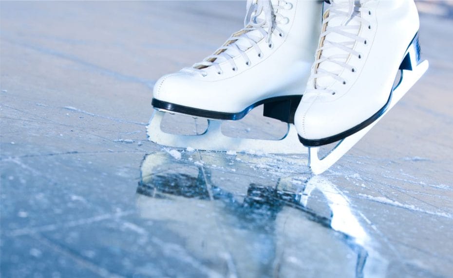 Ice skates and their reflection on ice.
