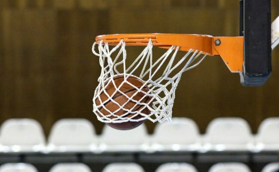 A basketball falling through a hoop.