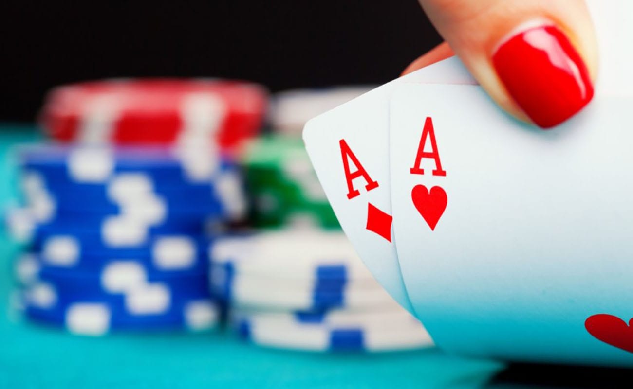 two ace cards with stacks of poker chips in the blurred background