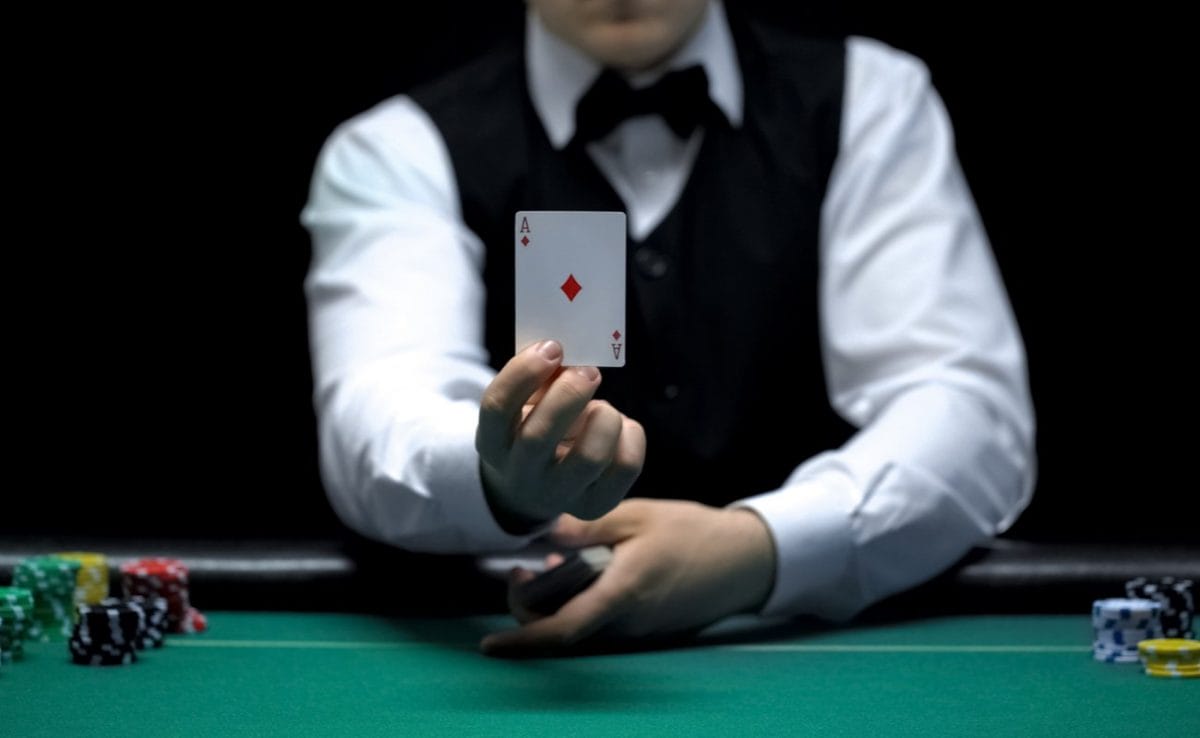 Casino dealer shows an ace card in front of the camera.