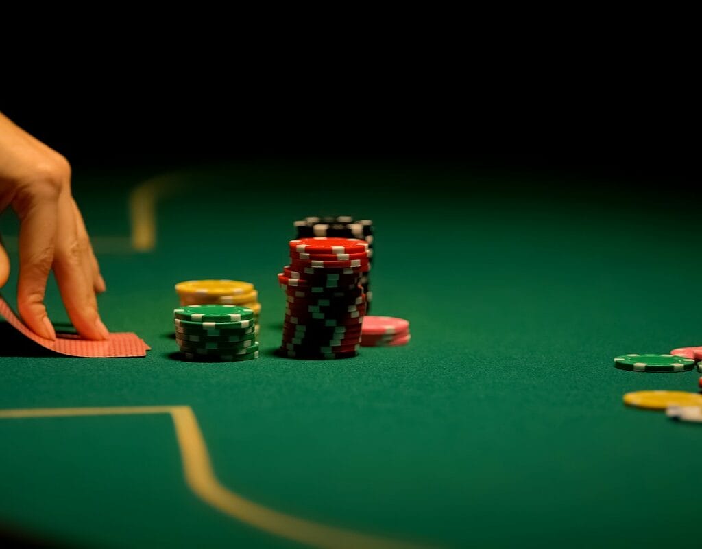 Female hands looking at cards on poker table