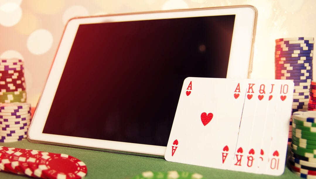 Ipad with poker chips around and a poker hand