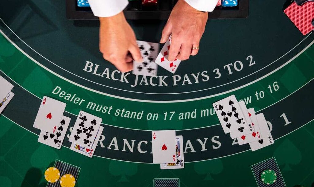 Top view of a blackjack casino table with cards and chips on the table.