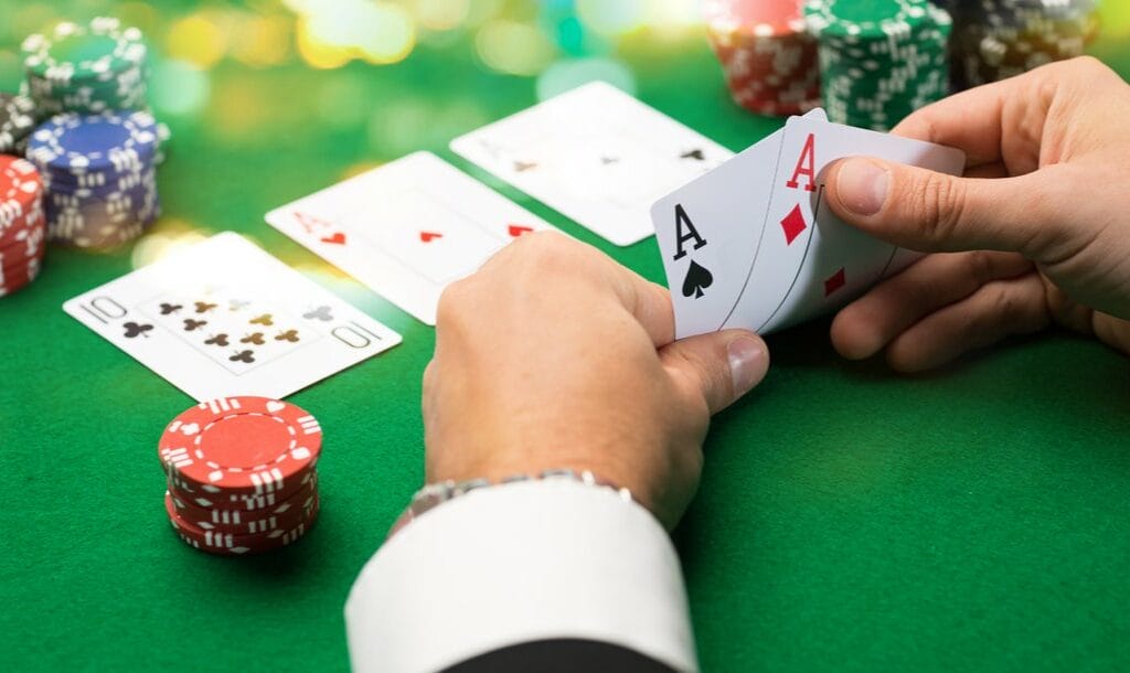 A poker player checks his hole cards.