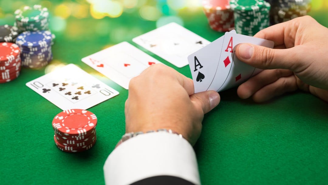 A poker player checks his hole cards.