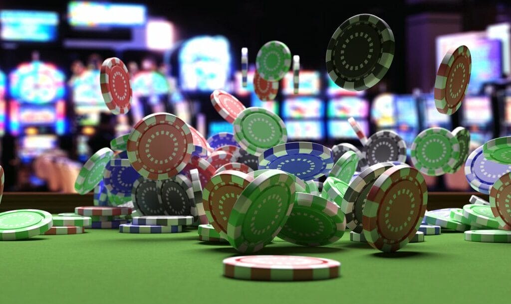Poker chips flying around on a casino table with slot machines in the background.
