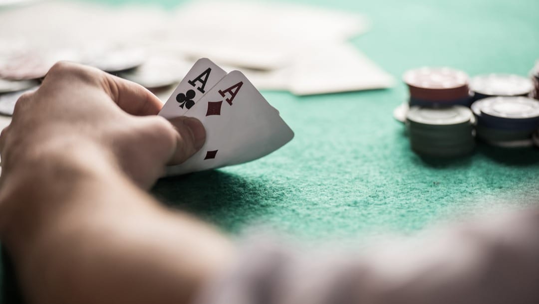 A poker player looks at their two aces.