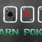 A blackboard with four aces drawn on it in chalk. Below the cards are the words “Learn Poker”.