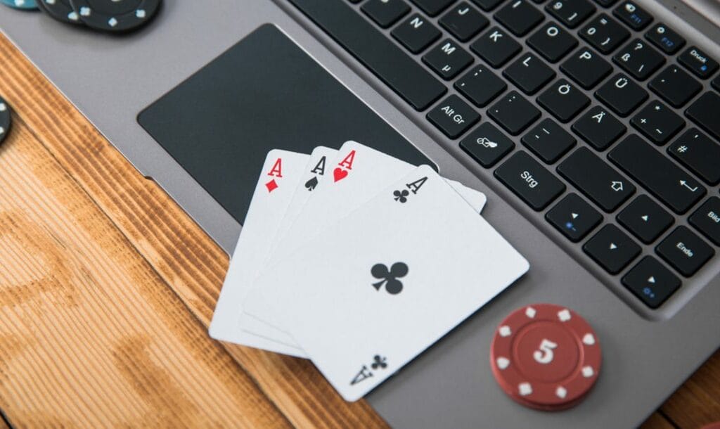 Four Aces and some poker chips on a laptop.