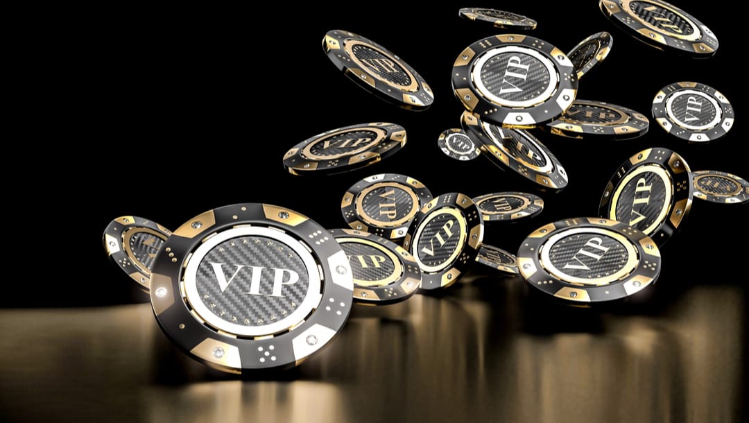 Poker chips with VIP written on them falling onto a table.