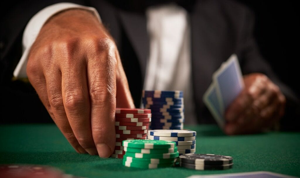 A poker player picks up a stack of chips.
