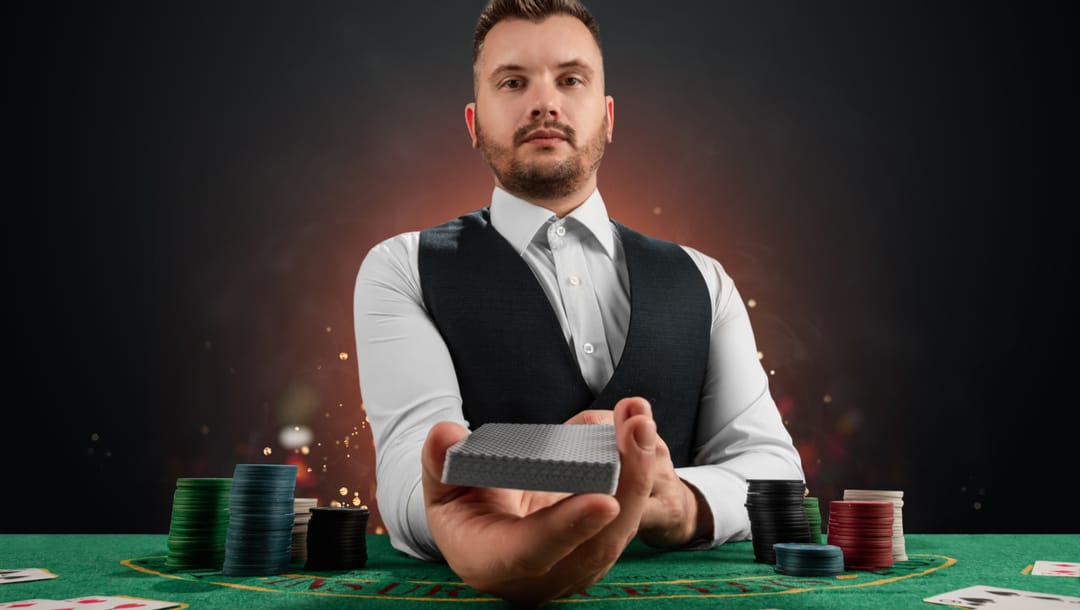 A male dealer presents a deck of cards at a poker table.