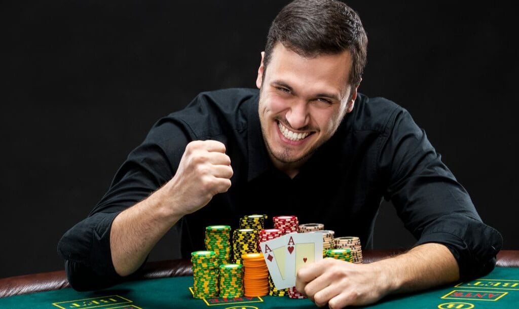 A happy poker player reveals two aces.