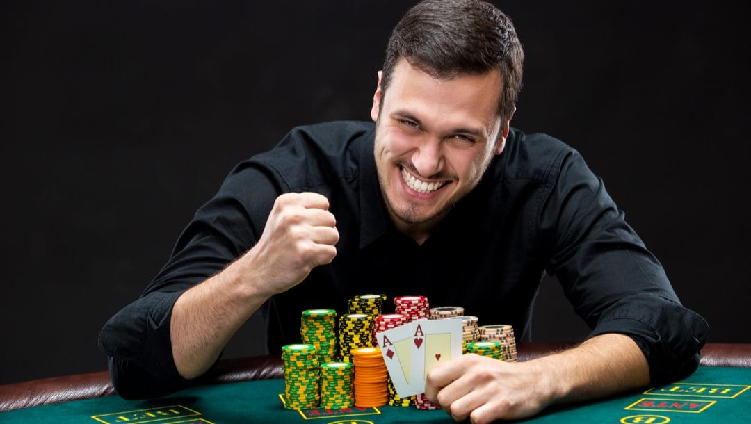 A happy poker player reveals two aces.