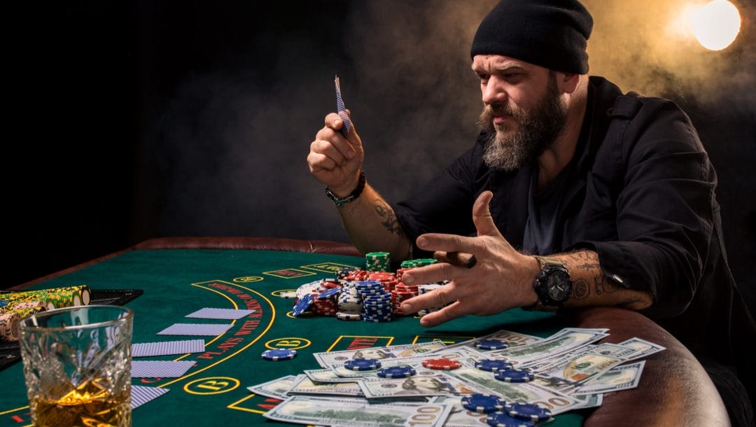 A frustrated poker player looks at his cards.