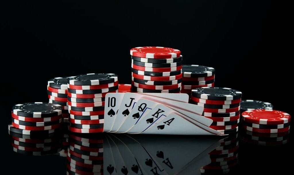 Poker chips and cards on a black surface.