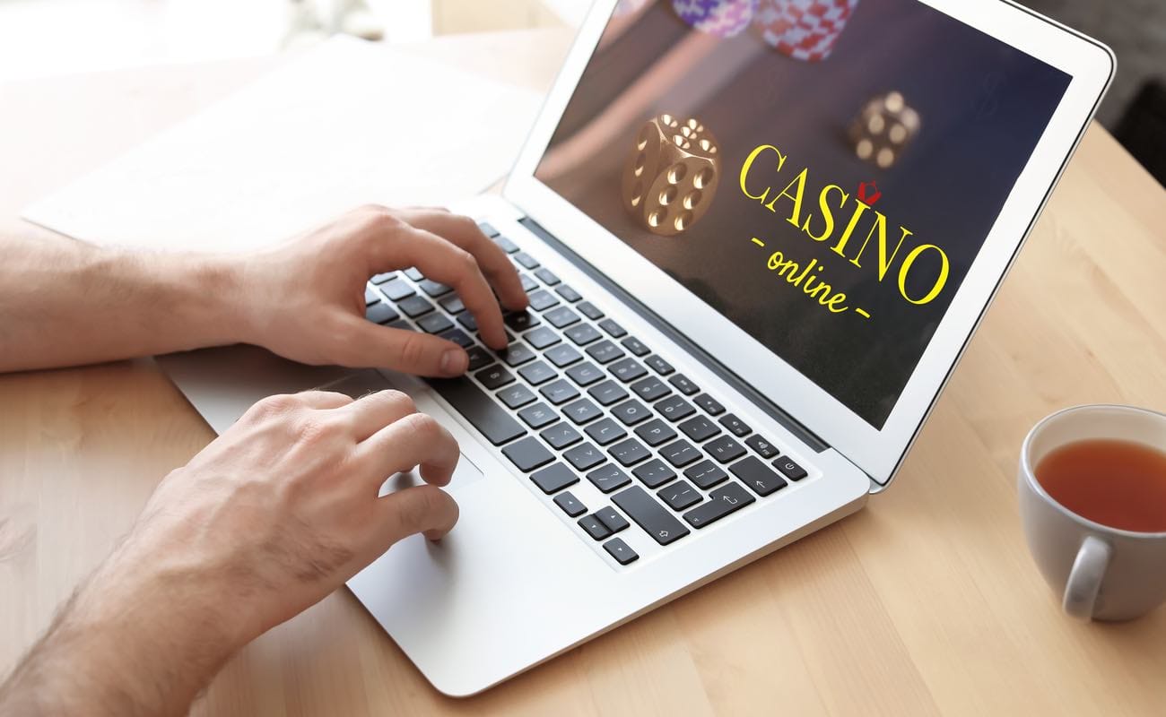 A close-up of a person playing on an online casino site on his laptop.