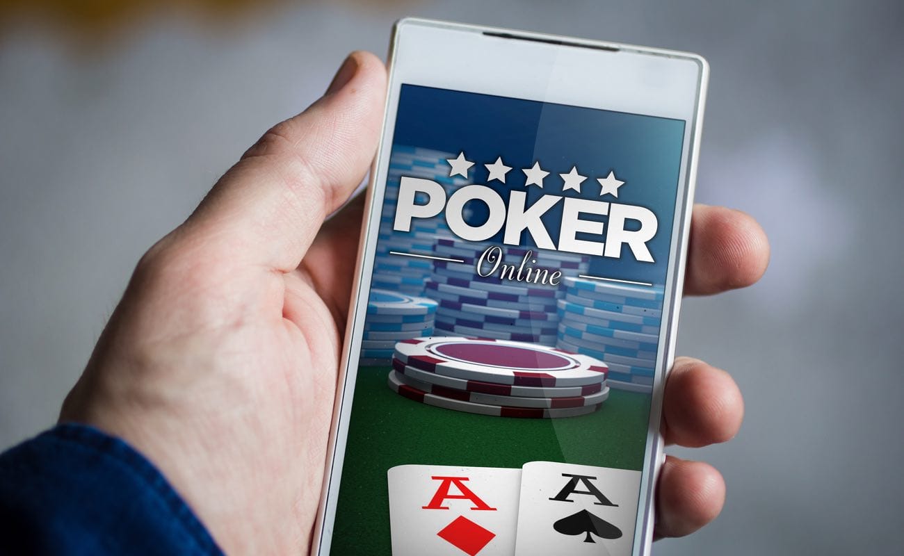 A person holding a smartphone with online poker on the screen.