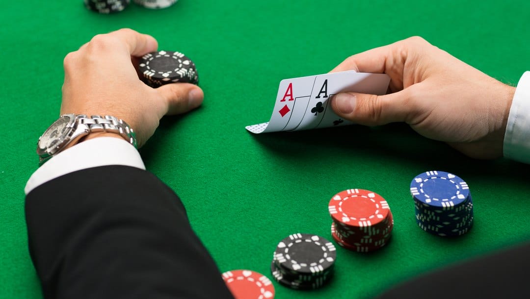 A poker player checks his cards before placing a bet.